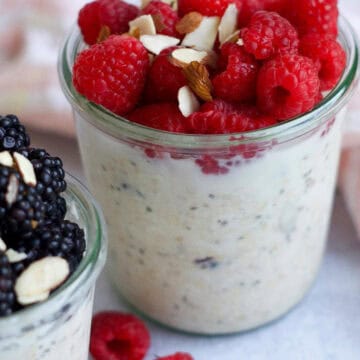 Strawberry chia pudding in a glass jar, topped with fresh berries and a drizzle of honey