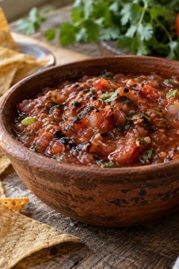 Bowl of chunky roasted tomato salsa roja with tortilla chips