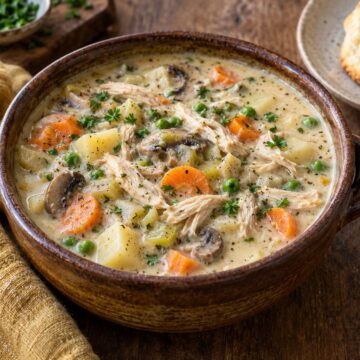 Creamy chicken pot pie soup with potatoes, carrots, peas, and mushrooms