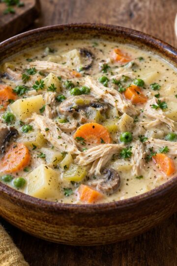 Creamy chicken pot pie soup with potatoes, carrots, peas, and mushrooms