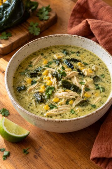 Creamy roasted poblano chicken soup with shredded chicken, corn, and cilantro.